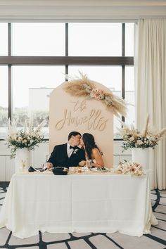 a bride and groom kissing in front of a sign