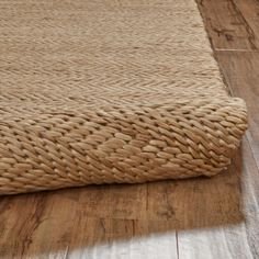 a close up of a rug on the floor with wood floors and white walls in the background