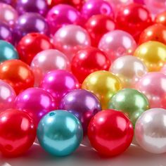 many different colors of pearls on a white surface