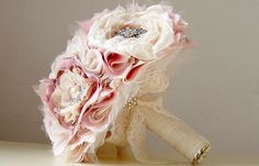 a bridal bouquet with pink and white flowers on it sitting on top of a table