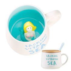 there is a cup with a toy in it and a mug next to it that says lacticious sea