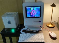 an apple computer sitting on top of a desk next to a keyboard and mouse,