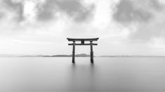 a large body of water with a wooden structure in the middle and clouds above it