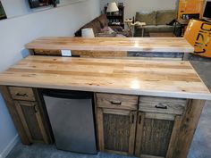 a kitchen island made out of wood with a refrigerator and dishwasher in the middle