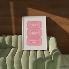 two pink tickets sitting on top of a green couch