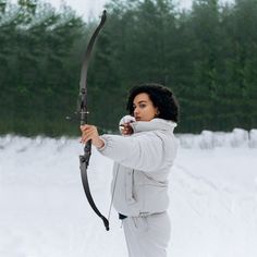 a woman holding a bow and arrow in the snow