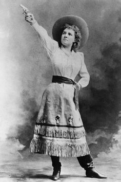 an old black and white photo of a woman with her arms in the air