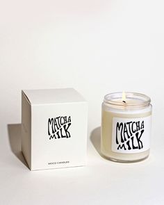 a candle sitting next to a box on a white surface with the words match milk printed on it