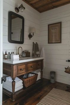 a bathroom with white walls and wood floors, including a wooden sink vanity topped with towels