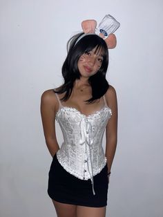 a woman wearing a white corset with ears on her head