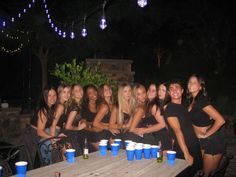 a group of women sitting around a table with cups