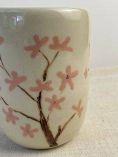 a white cup with pink flowers painted on it