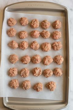 raw and uncooked meatballs on a baking sheet ready to be cooked in the oven