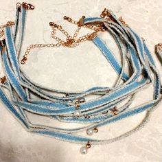 a blue and white necklace with pearls on it's end is sitting on a lace tablecloth