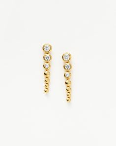 These drop studs feature rounded beads that graduate in size, matched with cubic zirconia stones. Let them take centre stage in your ear stack or team with pavé studs. Metal: 18k Recycled Gold Plated Vermeil on Recycled Sterling Silver Stone: White Cubic Zirconia Dimensions: 26mm x 4.9mm Weight: 3.4g Product Code: GU-G-E5-CZ Tennis Jewelry, Mixed Metal Jewelry, Ear Stack, Centre Stage, Diamond Gift, Festival Jewelry, Cubic Zirconia Earrings, Zirconia Earrings, Engraved Necklace