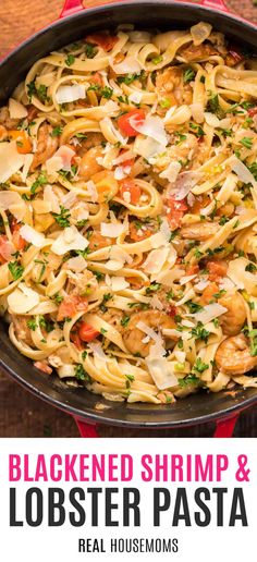 a skillet filled with shrimp and lobster pasta on top of a wooden table