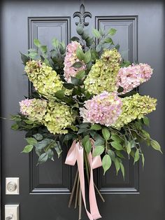 a bouquet of pink and green flowers on the front door