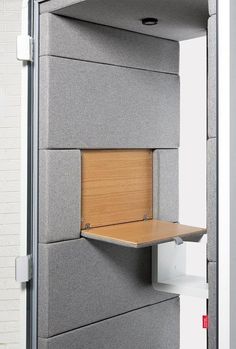 an office cubicle with a wooden shelf in it