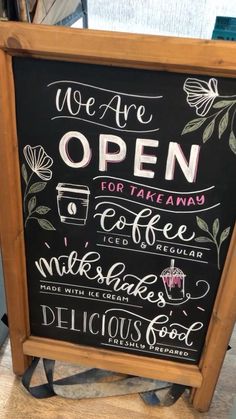 a blackboard sign that says we are open for takeaway coffee, milkshake and delicious food