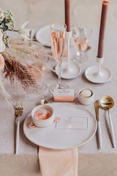 the table is set with two champagne flutes and place settings for guests to sit at