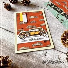 a birthday card with an orange car and pine cones on the table next to it