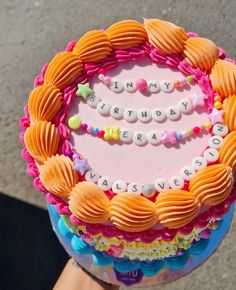 a birthday cake with the words happy birthday written on it, in front of someone's hand