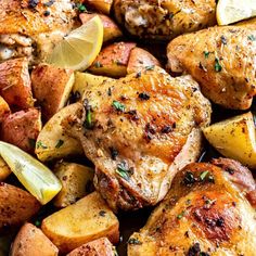 chicken and potatoes in a pan with lemon wedges