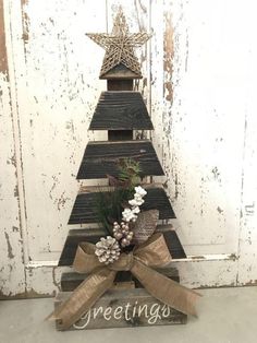 a christmas tree made out of pallet wood with the word greetings written on it