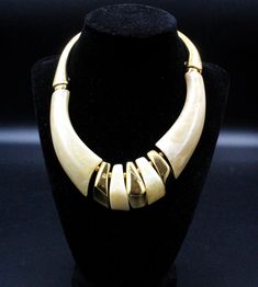 "DESCRIPTION: Step into the glamour of the 1980s with this striking designer necklace from Napier, showcasing an exquisite Art Deco style. Crafted from marbleized lucite with refined gold-tone accents, the piece epitomizes the elegance of the era. The necklace is marked with the iconic \"NAPIER,\" affirming its authenticity and designer pedigree. In impeccable condition, this choker necklace measures a chic 14 inches in length by 1 1/2 inches in width, offering a bold statement piece that seamlessly blends vintage charm with timeless style. NOTE: Insurance fee and handling fee are included in the shipping fee for items worth $400 and above. SHIPPING: The shipping fee includes postage, packaging, and handling. We typically ship items within one day of receiving payment. If you're buying mul Luxury Art Deco Necklaces With Polished Finish, Gold Multi-strand Costume Jewelry Necklace, Modernist Hallmarked Yellow Gold Jewelry, 80s Art Deco, Luxury Hallmarked Modernist Necklace, Black Multi-strand Costume Jewelry Necklace, Heart Dangle Earrings, Brass Necklace, Gold Tone Metal