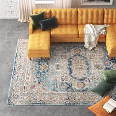 a living room with yellow couches and rugs