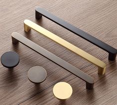 an assortment of different types of handles and knobs on a wooden surface, including one for the door