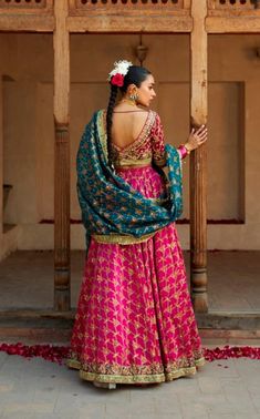 The wedding Bridal Lehenga Choli and Blue Dupatta Dress is a breathtaking masterpiece adorned with gota, threads, sequins, zardosi, and gold work. Premium quality fabric and lavish designs make this Lehenga Dress an epitome of beauty and grace. Bridal Choli: The choli in magenta color is beautifully adorned with goldwork and hand-crafted gota and zardosi work. Goldwork and shimmering sequins give a traditional touch to this perfectly stitched choli with half sleeves. Embroidery and threads give Bridal Choli, Dupatta Dress, Lehenga Dress, Blue Dupatta, Bridal Dupatta, Sleeves Embroidery, Zardosi Work, Raw Silk Fabric, Magenta Color