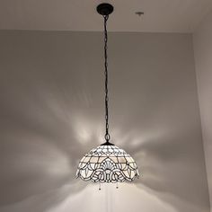 a chandelier hanging from the ceiling in a room with white walls and flooring