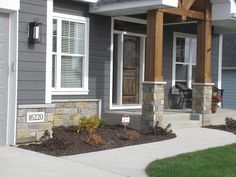 a gray house with white shutters and a front porch