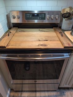 a stainless steel oven with wooden counter tops