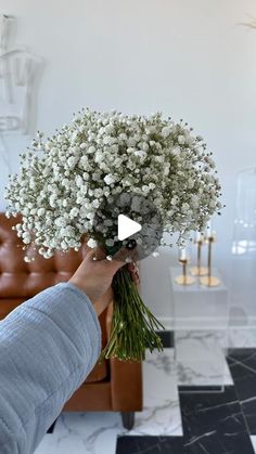 a person holding a bunch of flowers in their hand with the video screen showing them