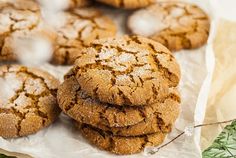 a pile of cookies sitting on top of a piece of wax paper next to some sprigs