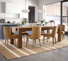 a dining room table with chairs and a rug