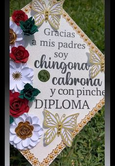 a graduation cap decorated with paper flowers and butterflies on the front is shown in spanish