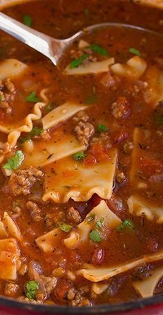 a red pot filled with pasta and meat soup