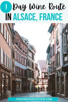 a cobblestone street in france with text overlay that reads one day wine route in alsace, france