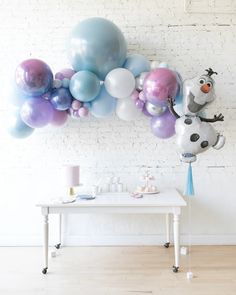 a table topped with balloons next to a wall