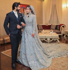 a man and woman in formal wear standing next to each other on a wooden floor