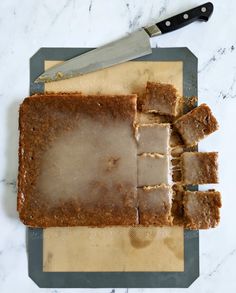 a cutting board topped with sliced up brownies and a knife next to it on top of a counter