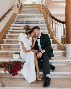 a bride and groom sitting on the stairs