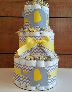 a diaper cake made to look like an elephant with yellow and gray decorations on it