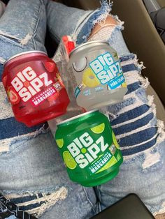 three big sip cans sitting on the back of someone's jeans in their car