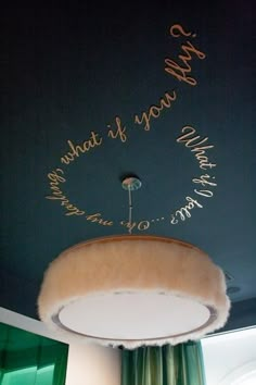 the ceiling is decorated with writing on it and a round light fixture in the center