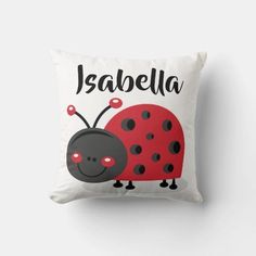 a red and black ladybug pillow with the words,'jabella'on it