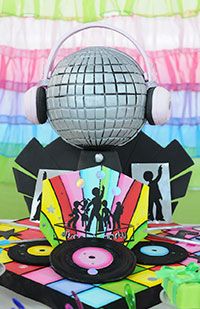 a disco ball with headphones on top of it and some party decorations in the background